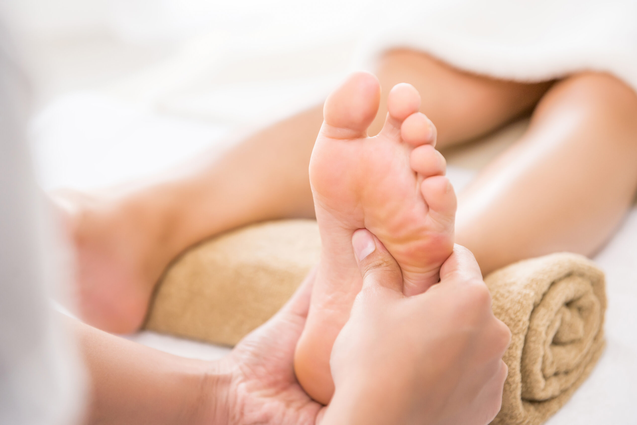 Professional therapist giving traditional thai foot massage to a woman in spa